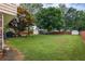 Lush green backyard with detached garages, mature trees, fencing, and seating area at 618 Summerville Dr, Lawrenceville, GA 30046