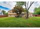 Green backyard with mature trees, a patio area with furniture, and the home's exterior at 618 Summerville Dr, Lawrenceville, GA 30046