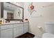 Bright bathroom featuring a white vanity with drawers and a decorative mirror and floral wall art at 618 Summerville Dr, Lawrenceville, GA 30046