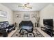 Cozy living room with black leather sofas, a modern glass table, and a ceiling fan at 618 Summerville Dr, Lawrenceville, GA 30046
