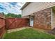 Back door with brick and wood fence including a small patch of green grass at 618 Summerville Dr, Lawrenceville, GA 30046