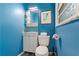 Bright blue half-bathroom featuring modern fixtures, mosaic tiling, and a window at 2493 Springdale Rd, Atlanta, GA 30315