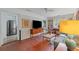 Cozy living room featuring a brick wall, TV, and view into kitchen at 2493 Springdale Rd, Atlanta, GA 30315