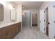 Bathroom featuring a double vanity, glass shower, and neutral tile, with a walk-in closet visible at 512 Winston Croft Cir # 56, Johns Creek, GA 30022