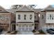 Charming brick townhome with a gray roof, black metal awnings, and a two-car garage at 512 Winston Croft Cir # 56, Johns Creek, GA 30022