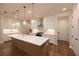 Modern kitchen with white cabinets, stainless appliances, a central island, and hardwood flooring at 512 Winston Croft Cir # 56, Johns Creek, GA 30022