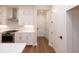 Well-lit kitchen featuring white cabinets, stone countertops, stainless steel oven, and hardwood floors at 512 Winston Croft Cir # 56, Johns Creek, GA 30022