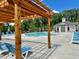 View of the community pool area with lounge chairs, umbrellas, and a clubhouse, perfect for relaxation and recreation at 512 Winston Croft Cir # 57, Johns Creek, GA 30022