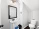 Powder room featuring a pedestal sink, framed mirror, and modern fixtures at 1016 Buckeye Ln, Villa Rica, GA 30180