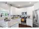 Bright kitchen features white cabinets, stainless steel appliances, and granite countertops at 1016 Buckeye Ln, Villa Rica, GA 30180
