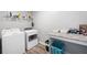 Well-lit laundry room with washer, dryer, storage shelf, and folding counter at 1016 Buckeye Ln, Villa Rica, GA 30180