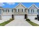 Townhome exterior with attached garage, brick foundation, shutters, and manicured lawn at 11730 Chatham Dr, Hampton, GA 30228