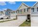 Townhomes with attached garages, well-manicured lawns, and concrete driveway on a sunny day at 11730 Chatham Dr, Hampton, GA 30228