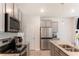 Bright kitchen with stainless steel appliances, granite countertops, and grey cabinets at 11730 Chatham Dr, Hampton, GA 30228