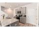 Galley-style kitchen with stainless appliances, granite counters, and grey cabinets at 11730 Chatham Dr, Hampton, GA 30228