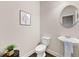 Cozy half bathroom features a pedestal sink, round mirror, and neutral decor at 2396 Whiteoak Se Bnd # 16, Smyrna, GA 30080
