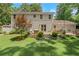 Exterior backyard featuring a lush lawn, patio area, and lush landscaping with a stone retaining wall at 435 Grenock Cir, Atlanta, GA 30328