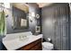 Stylish powder room features a marble countertop, decorative mirror, and dark gray walls at 435 Grenock Cir, Atlanta, GA 30328
