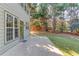 View of the backyard featuring a concrete patio, green grass, and lots of trees at 5115 Amberden Hall Dr, Suwanee, GA 30024
