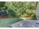 Spacious backyard with a patio and lush greenery providing shade and privacy at 5115 Amberden Hall Dr, Suwanee, GA 30024