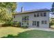 Expansive backyard with green lawn, concrete patio and multiple windows for natural light at 5115 Amberden Hall Dr, Suwanee, GA 30024
