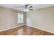 Cozy bedroom featuring hardwood floors, neutral walls, and a window with a view at 5115 Amberden Hall Dr, Suwanee, GA 30024
