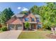 Charming brick two-story home with a three-car garage and well-manicured lawn at 5115 Amberden Hall Dr, Suwanee, GA 30024