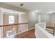 Upstairs hallway with hardwood floors and views of foyer at 5115 Amberden Hall Dr, Suwanee, GA 30024