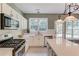 Bright kitchen with stainless steel appliances, white cabinetry, and tile backsplash at 5115 Amberden Hall Dr, Suwanee, GA 30024