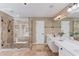 Spacious main bathroom includes glass shower, tub, and double sink vanity at 5115 Amberden Hall Dr, Suwanee, GA 30024