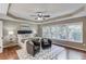 Cozy primary bedroom with tray ceiling, ceiling fan, and sitting area at 5115 Amberden Hall Dr, Suwanee, GA 30024
