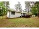 Exterior view of a white brick home showcasing the backyard and deck area at 537 Eastside Dr, Dacula, GA 30019