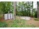 Backyard featuring a storage shed and an above-ground pool surrounded by trees at 537 Eastside Dr, Dacula, GA 30019