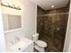 A bathroom featuring a modern vanity and walk-in shower with decorative dark tile at 537 Eastside Dr, Dacula, GA 30019