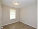 A clean and simple bedroom with wood-look flooring and a bright window at 537 Eastside Dr, Dacula, GA 30019