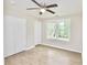 A simple bedroom with a ceiling fan, light-toned floors, a window and a double door closet at 537 Eastside Dr, Dacula, GA 30019