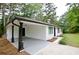 View of the home's carport area and side exterior showing the painted brick and manicured landscape at 537 Eastside Dr, Dacula, GA 30019