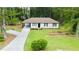 Charming exterior of a white home, surrounded by lush landscaping and a long driveway at 537 Eastside Dr, Dacula, GA 30019