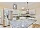Modern kitchen features stainless steel appliances, granite countertops and designer pendant lighting at 537 Eastside Dr, Dacula, GA 30019