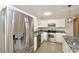 The kitchen features stainless steel appliances, granite countertops, white cabinets and light-toned wood floors at 537 Eastside Dr, Dacula, GA 30019
