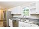 This kitchen boasts granite countertops, a stainless steel dishwasher and a stainless steel refrigerator at 537 Eastside Dr, Dacula, GA 30019