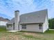 Back exterior view showing the siding, chimney, windows, and a concrete patio at 114 Saddle Wood Dr, Dallas, GA 30157