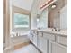 Bright bathroom featuring a large window above a soaking tub and double sink vanity at 114 Saddle Wood Dr, Dallas, GA 30157