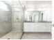 Modern bathroom with a glass-enclosed shower, gray tiling, dual sinks, and granite countertops at 3133 Quinn Pl, Atlanta, GA 30341