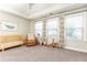 Bedroom featuring a crib, recliner, plush carpet, and three windows with leafy patterned curtains at 3133 Quinn Pl, Atlanta, GA 30341