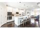 Modern kitchen with white cabinets and stainless appliances that opens up to a living area and a staircase at 3133 Quinn Pl, Atlanta, GA 30341