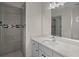 Well-lit bathroom with gray tile shower, mosaic accent, large mirror, and white vanity at 8630 Moor Park Run, Duluth, GA 30097