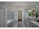 Luxurious bathroom with a glass-enclosed shower, soaking tub, dual vanities, and modern fixtures at 8630 Moor Park Run, Duluth, GA 30097