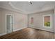 Bedroom featuring a decorative ceiling, hardwood floors, and multiple windows at 8630 Moor Park Run, Duluth, GA 30097