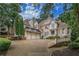 Impressive brick home featuring mature trees, a three-car garage, and ample parking space at 8630 Moor Park Run, Duluth, GA 30097